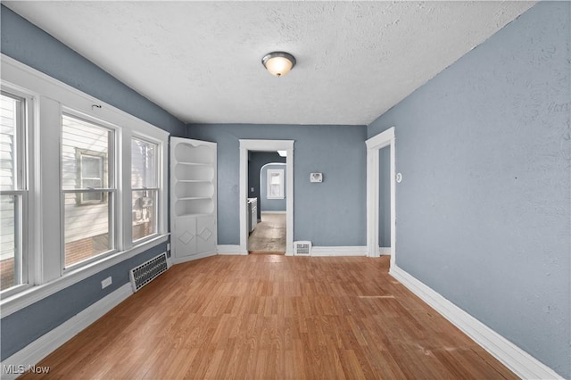 empty room featuring wood-type flooring and a textured ceiling