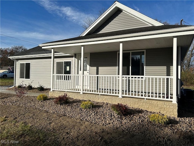 view of side of home featuring covered porch