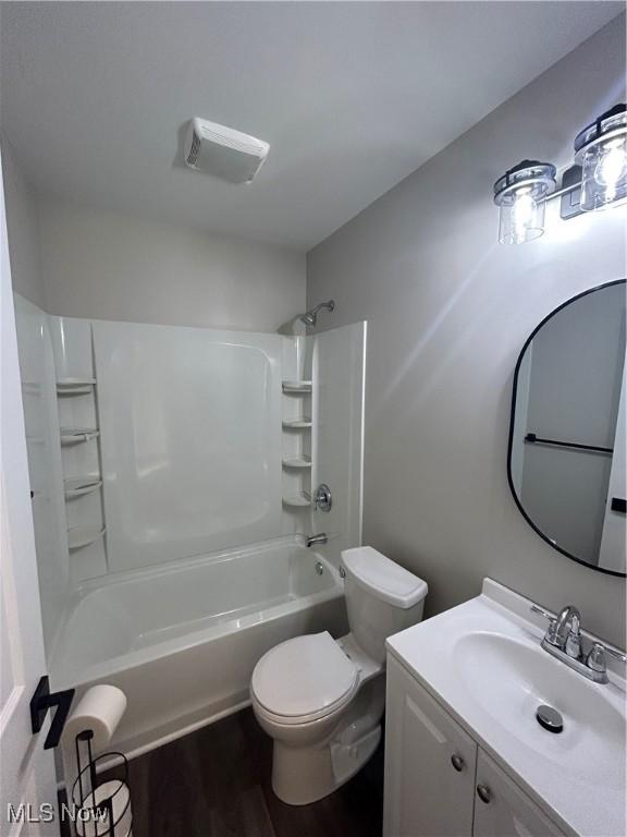 full bathroom with wood-type flooring, vanity, toilet, and shower / washtub combination