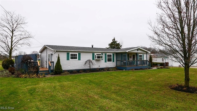 view of front of property with a wooden deck and a front lawn