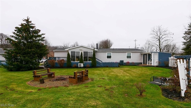 rear view of house featuring a lawn and a sunroom