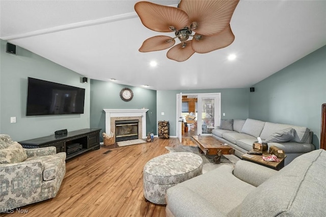 living room featuring vaulted ceiling, ceiling fan, light hardwood / wood-style flooring, and french doors