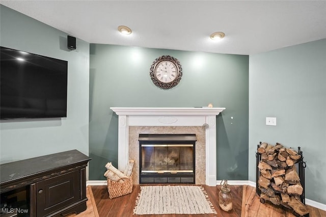 living room with a high end fireplace and hardwood / wood-style floors