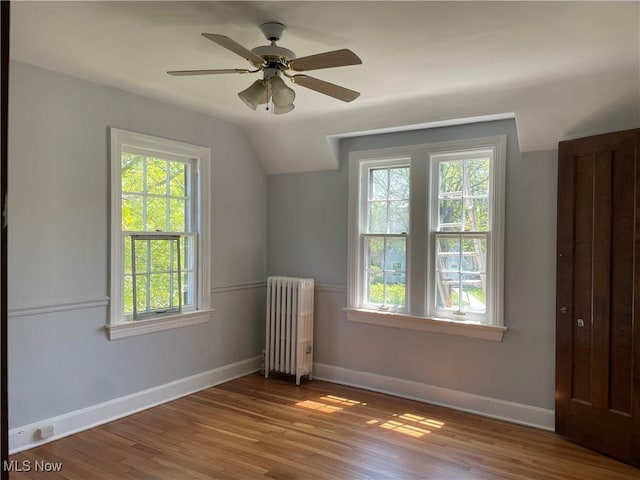 additional living space with radiator, ceiling fan, hardwood / wood-style floors, and lofted ceiling