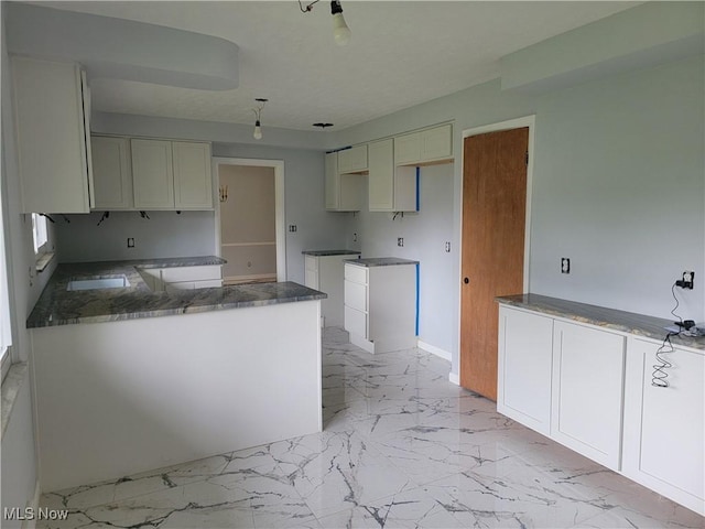 kitchen with white cabinetry and kitchen peninsula