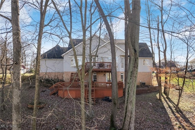 rear view of property featuring a wooden deck