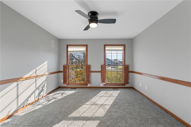 spare room with ceiling fan and carpet