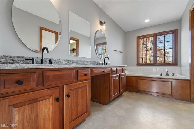 bathroom with vanity and a tub to relax in