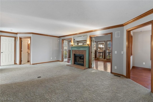 unfurnished living room with carpet flooring, crown molding, and a brick fireplace