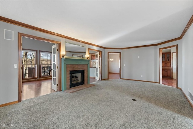 unfurnished living room featuring crown molding, carpet floors, and a brick fireplace