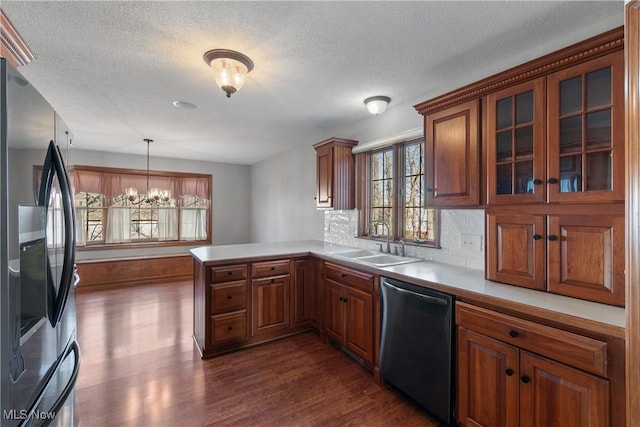 kitchen with hanging light fixtures, an inviting chandelier, dark hardwood / wood-style floors, kitchen peninsula, and appliances with stainless steel finishes