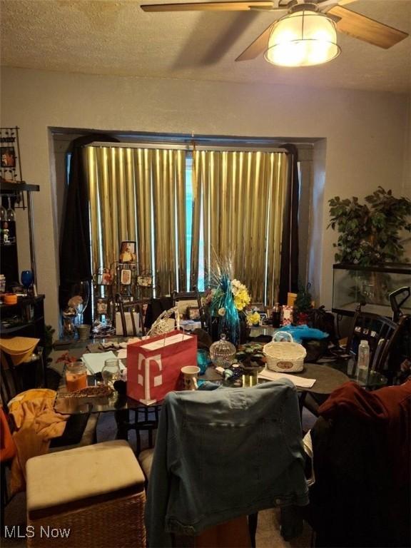 dining space with ceiling fan and a textured ceiling