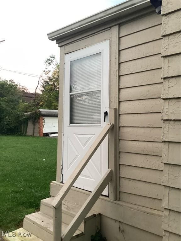 entrance to property featuring a lawn