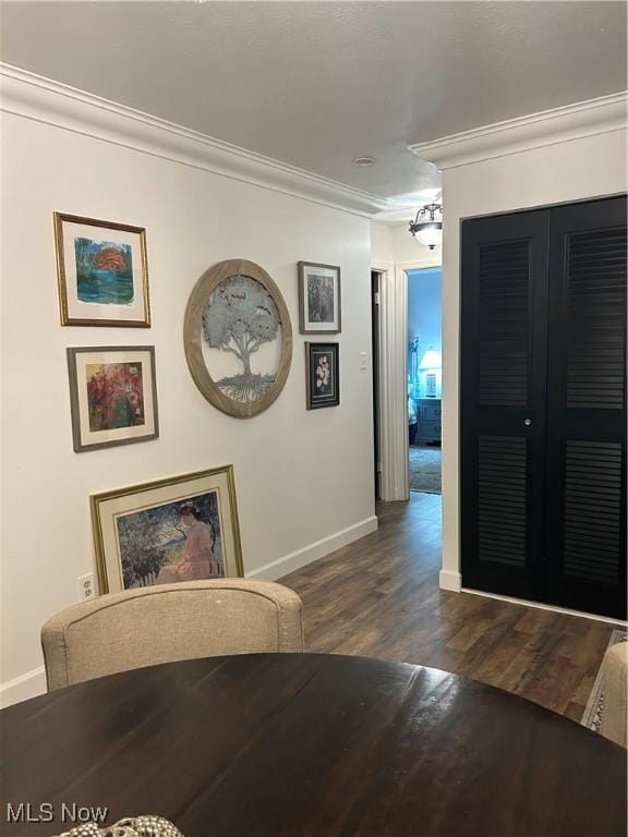 dining space featuring ornamental molding and dark hardwood / wood-style floors