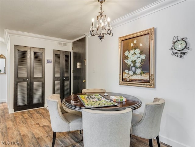 dining space with a notable chandelier, crown molding, french doors, and hardwood / wood-style flooring