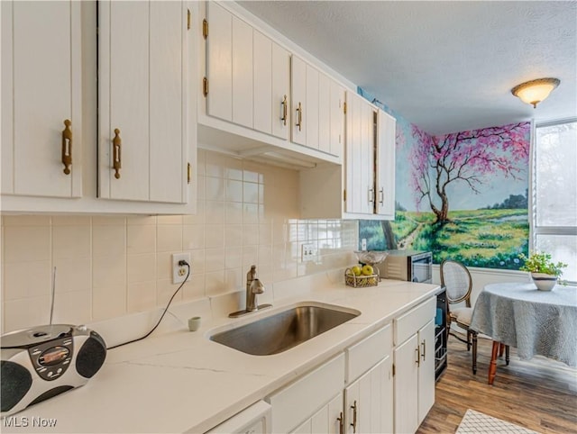 kitchen featuring light wood-type flooring, sink, and white cabinets