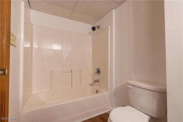 bathroom featuring hardwood / wood-style floors, a paneled ceiling, toilet, and  shower combination