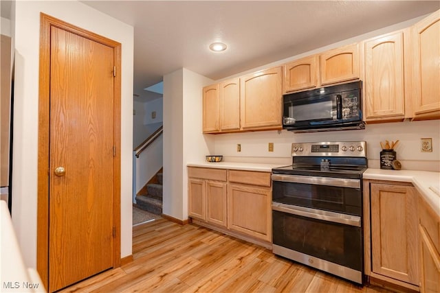 kitchen with light brown cabinets, stainless steel range with electric cooktop, and light wood-type flooring