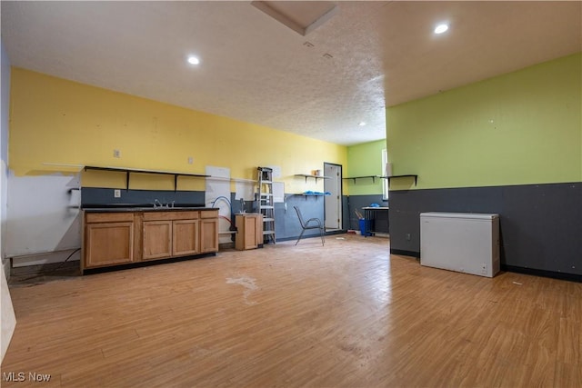 misc room with a textured ceiling and light wood-type flooring