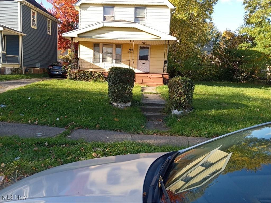 view of front facade featuring covered porch and a front yard