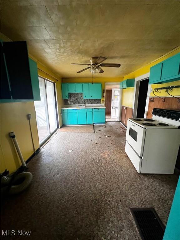 kitchen featuring white range with electric stovetop, decorative backsplash, ceiling fan, and carpet flooring