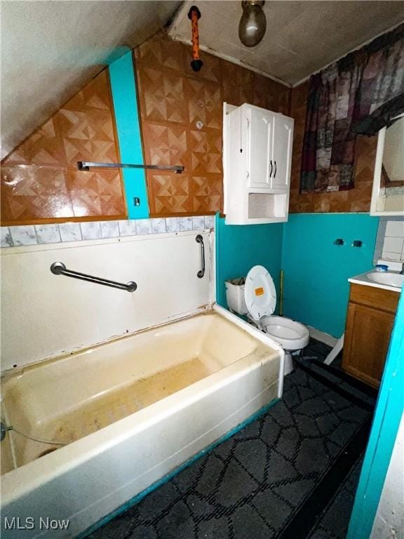 full bathroom with vanity, toilet, washtub / shower combination, and vaulted ceiling