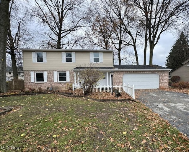 view of front property featuring a garage and a front lawn