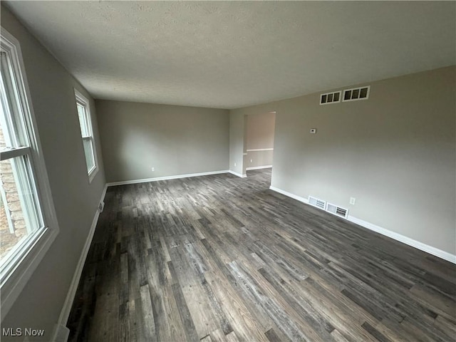 spare room with dark hardwood / wood-style flooring and a textured ceiling