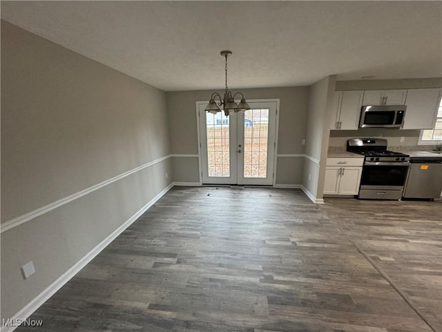 interior space featuring a chandelier, french doors, and dark hardwood / wood-style floors