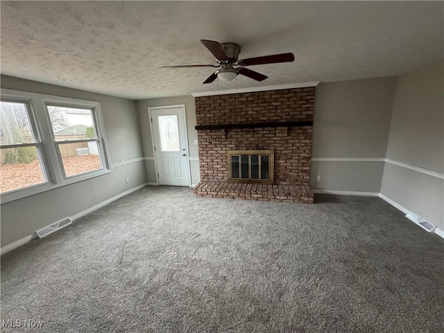 unfurnished living room with carpet flooring, ceiling fan, a fireplace, and a textured ceiling