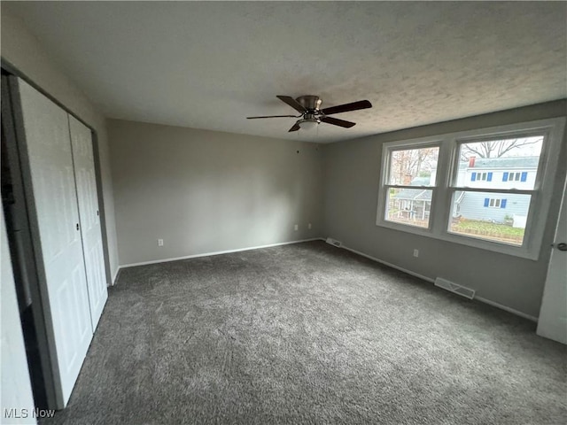 unfurnished bedroom featuring dark colored carpet and ceiling fan