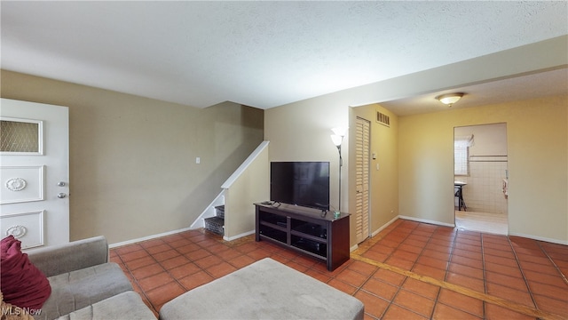 living room featuring a textured ceiling and dark tile patterned flooring