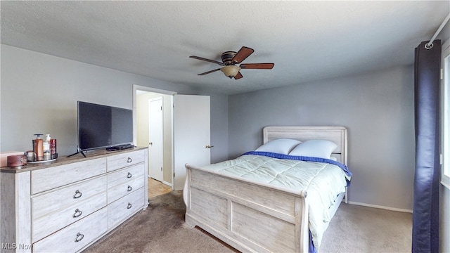 carpeted bedroom featuring ceiling fan and a textured ceiling