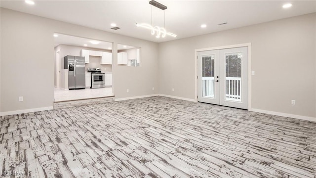 unfurnished living room featuring french doors and light hardwood / wood-style floors