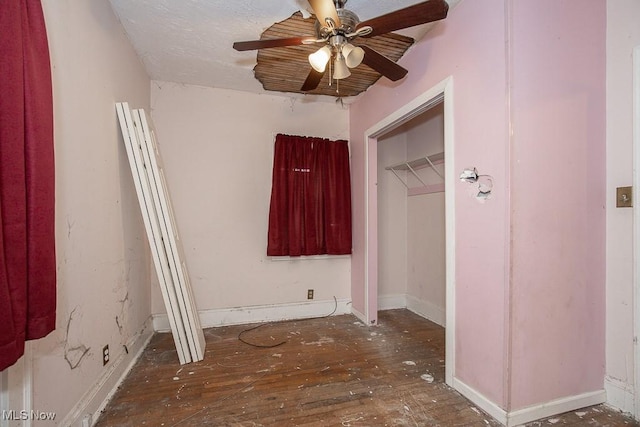 unfurnished bedroom with dark hardwood / wood-style floors, ceiling fan, and a closet