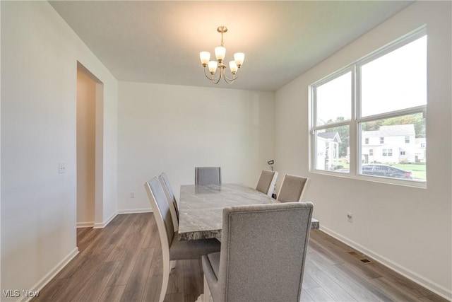 dining space with a chandelier and hardwood / wood-style floors