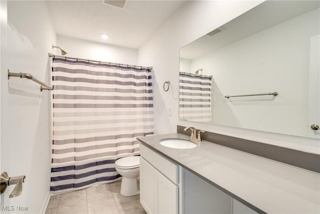 bathroom with tile patterned flooring, vanity, and toilet