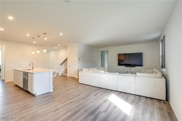 unfurnished living room featuring light hardwood / wood-style floors and sink