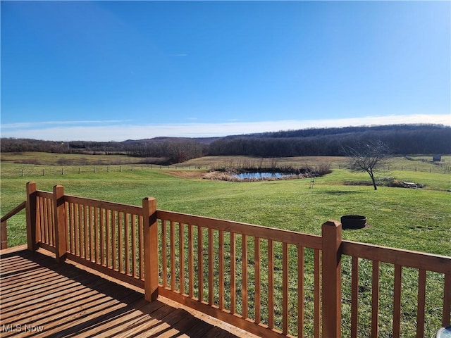 wooden terrace with a yard and a rural view