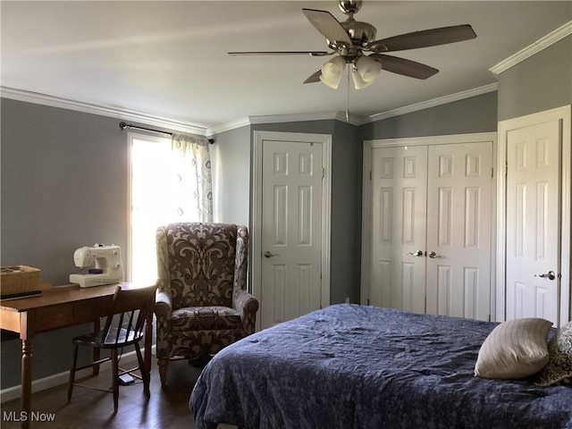 bedroom featuring ornamental molding, two closets, ceiling fan, dark hardwood / wood-style floors, and lofted ceiling