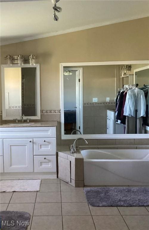 bathroom with tile patterned floors, vanity, crown molding, and vaulted ceiling