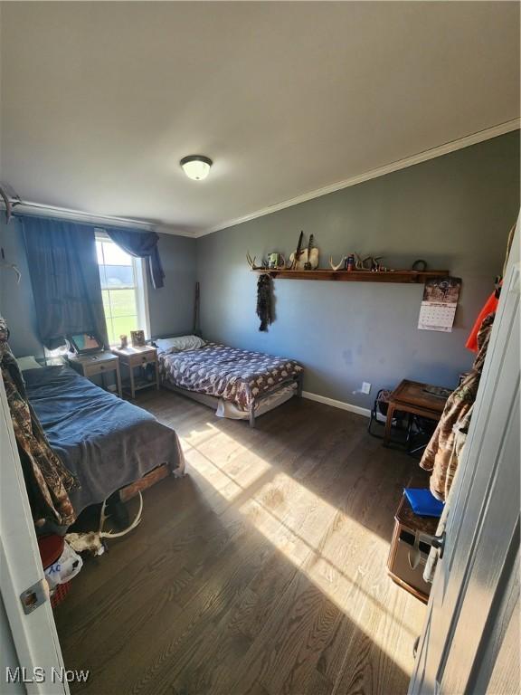 bedroom with hardwood / wood-style flooring and crown molding