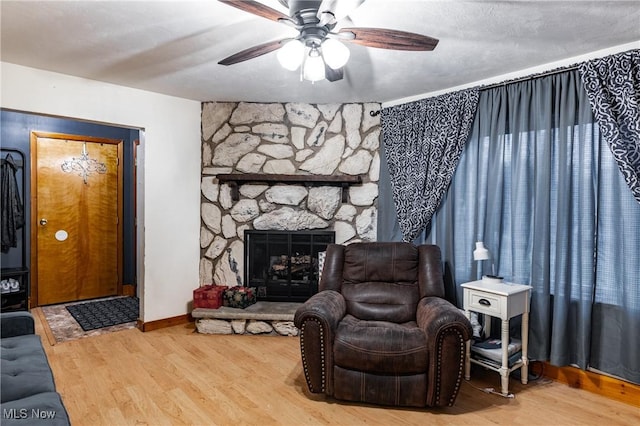 living room with a fireplace, ceiling fan, and hardwood / wood-style floors