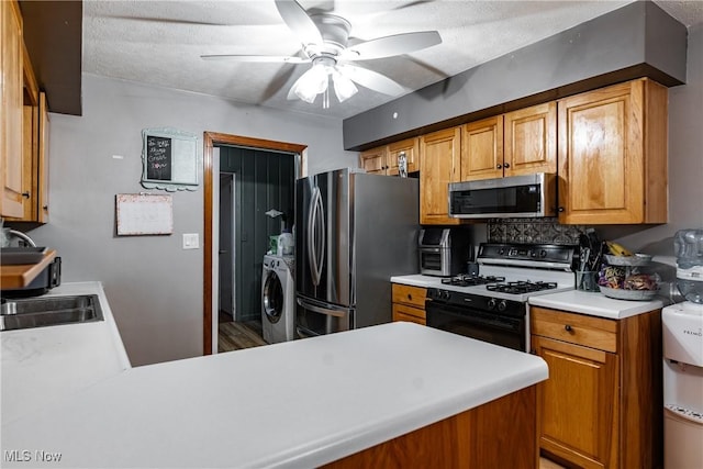 kitchen featuring decorative backsplash, a textured ceiling, appliances with stainless steel finishes, kitchen peninsula, and washer / clothes dryer