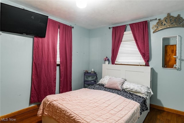 bedroom with dark wood-type flooring