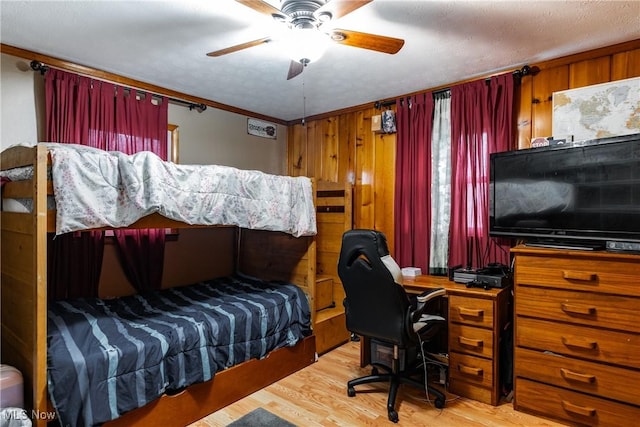 bedroom featuring hardwood / wood-style flooring, ceiling fan, ornamental molding, and wooden walls