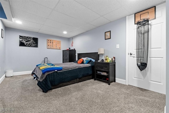 bedroom featuring baseboards, carpet floors, and a drop ceiling