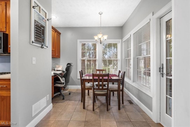 dining space featuring light tile patterned flooring, visible vents, a chandelier, and baseboards