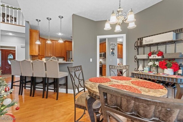 dining area with an inviting chandelier and light wood-style floors