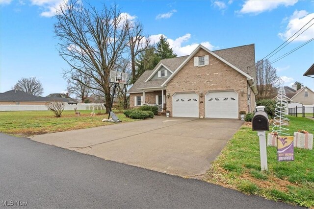 traditional home with a front yard, a garage, brick siding, concrete driveway, and fence
